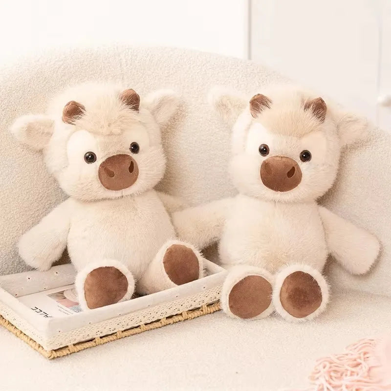 Two Toffee Highland cow plushies sitting side by side